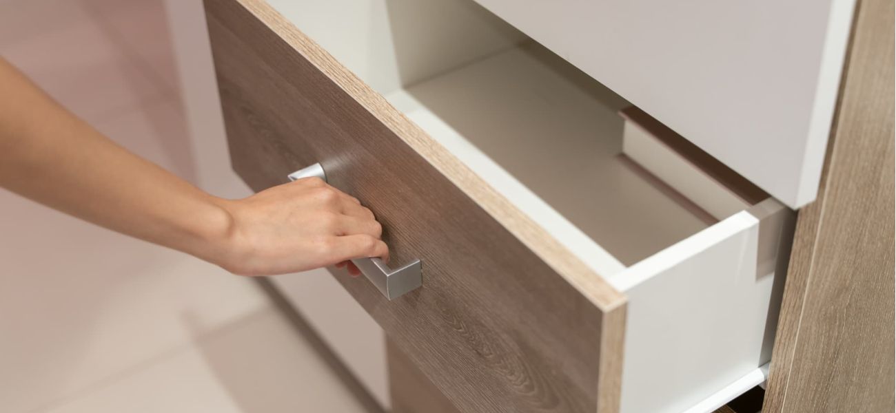 mujer abriendo una cajonera de armario