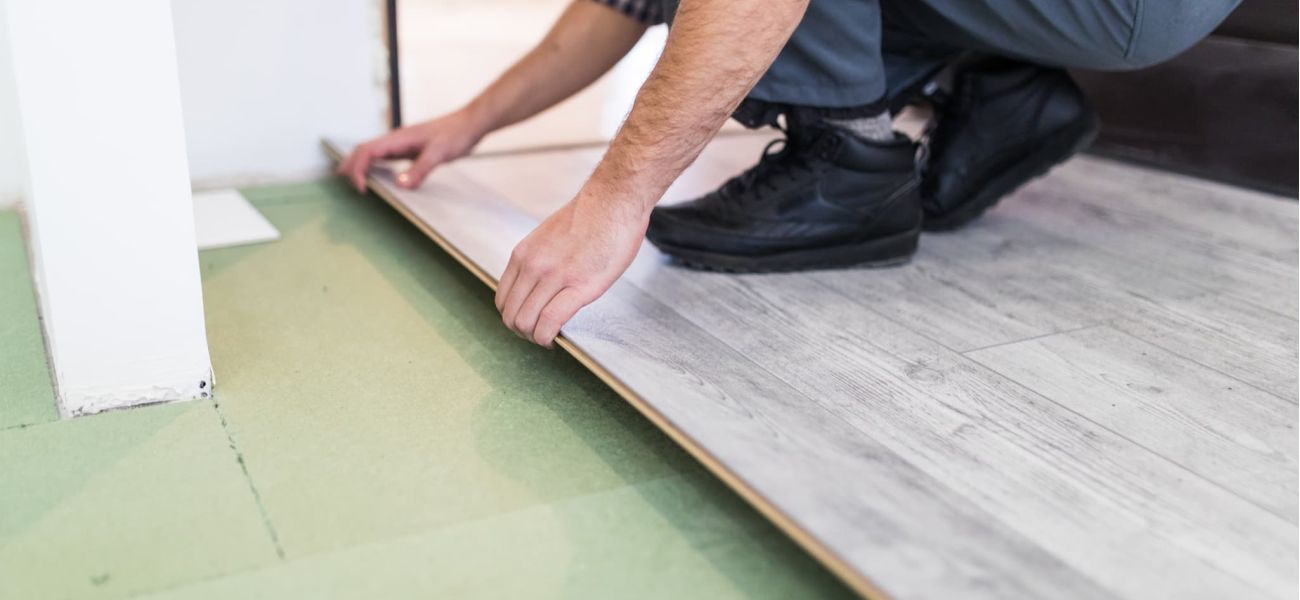 trabajador instalando suelo laminado