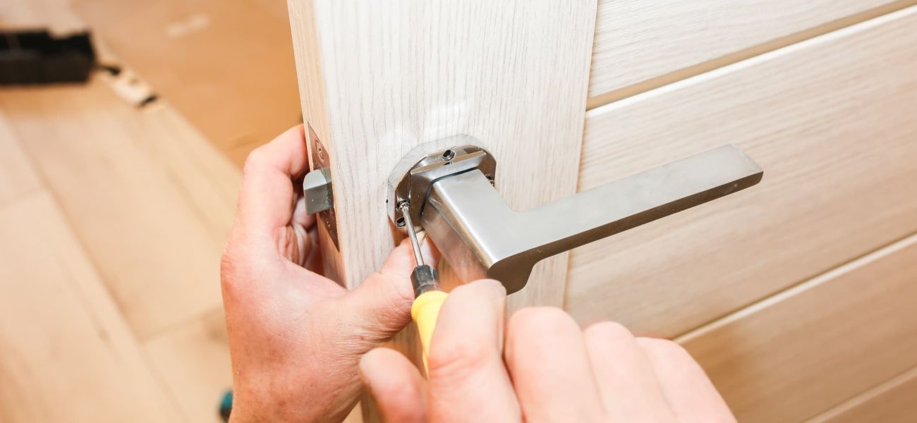hombre instalando manija puertas trabajos reparación mantenimiento apartamento